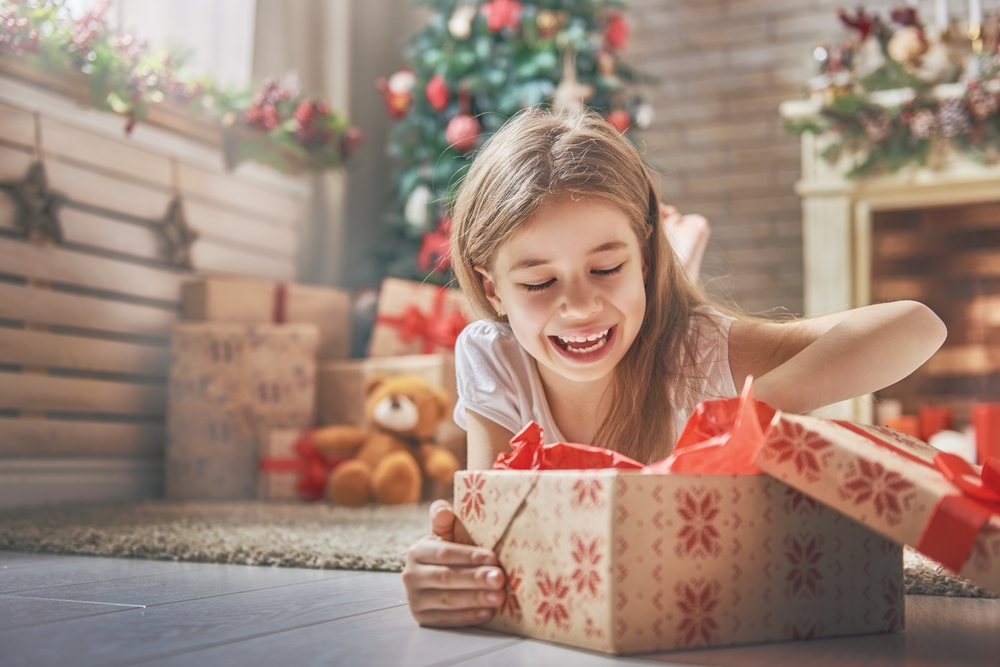 Little girl opening Christmas gift